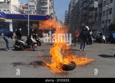 (210316) -- BEIRUT, 16. März 2021 (Xinhua) -- Demonstranten blockieren eine Straßenkreuzung in Beirut, Libanon, 16. März 2021. Demonstranten blockierten am Dienstag die meisten Straßen im Libanon bei Protesten gegen den massiven Zusammenbruch der nationalen Währung gegenüber dem Dollar und den Anstieg der Rohstoffpreise. (Xinhua/Bilal Jawich) Stockfoto