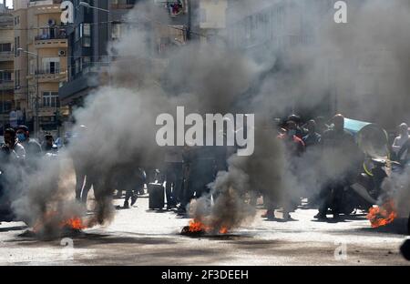 (210316) -- BEIRUT, 16. März 2021 (Xinhua) -- Demonstranten blockieren eine Straßenkreuzung in Beirut, Libanon, 16. März 2021. Demonstranten blockierten am Dienstag die meisten Straßen im Libanon bei Protesten gegen den massiven Zusammenbruch der nationalen Währung gegenüber dem Dollar und den Anstieg der Rohstoffpreise. (Xinhua/Bilal Jawich) Stockfoto