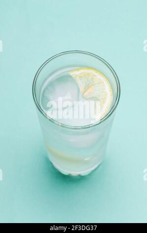 Cocktail mit Eis und Zitrone auf blauem Hintergrund Stockfoto