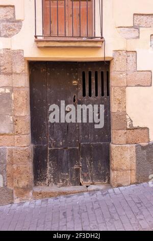 Alte Holztür mit Steinbogen, in Girona, Katalonien, Spanien Stockfoto