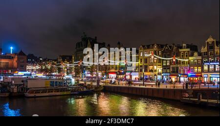 Damrak in Amsterdam bei Nacht in Holland, Niederlande Stockfoto