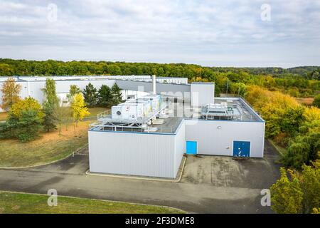 Servicegebäude im Industrie- oder Logistikpark. Erhöhte Ansicht eines kleinen Gebäudes mit Klimaanlagen auf dem Dach. Industrie und Logistik. Stockfoto