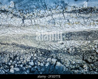 Draufsicht auf verschiedene Eisschweben auf der Wasseroberfläche von Drohne. Abstrakter Winter natürlicher Hintergrund. Stockfoto