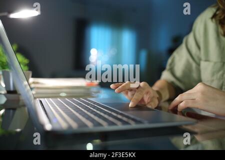 Nahaufnahme einer Frau, die mit der Hand auf dem Laptop surft Touchpad in der Nacht zu Hause Stockfoto