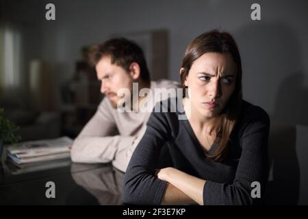 Verärgeres Paar, das sich gegenseitig ignoriert und im Wohnzimmer sitzt In der Nacht zu Hause Stockfoto
