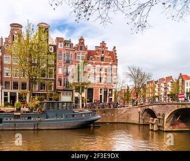 Fassaden und Hausboote entlang des Kanals im Herbst in Amsterdam in Holland, Niederlande Stockfoto