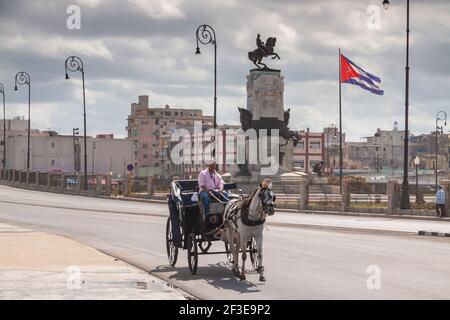 Havanna, Kuba - 23. März 2010: Eine Kutsche von einem weißen Pferd gezogen überquert die Straße, in der Nähe der Malecon, auf der Höhe des Antonio Maceo Park, in der Stockfoto