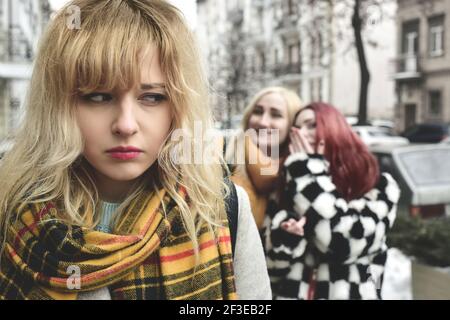 Eine junge depressive Studentin mit blonden Haaren, die von ihren Teenagerkollegen schikaniert wird, von Gefühlen der Verzweiflung gestört und unter Unterdrückung leidet. S Stockfoto