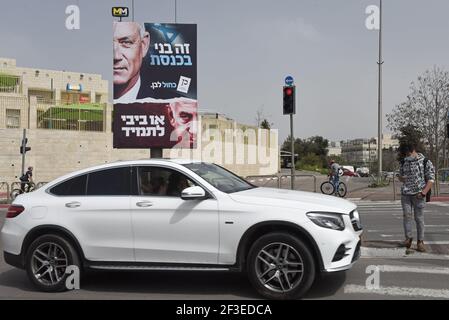 Jerusalem, Israel. März 2021, 15th. Ein Auto fährt am Montag, den 15. März 2021, in Jerusalem an einer Plakatwand für den Vorsitzenden der Blauen und Weißen Partei Benny Gantz (oben) und seinen rivalisierenden Premierminister Benjamin Netanjahu (unten) vorbei. Netanjahu steht vor seiner vierten Wiederwahl seit zwei Jahren, als Israelis am 23. März an die Urnen gehen. Foto von Debbie Hill/UPI Kredit: UPI/Alamy Live Nachrichten Stockfoto