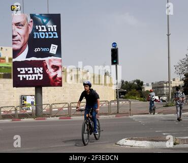 Jerusalem, Israel. März 2021, 15th. Ein Junge fährt am Montag, den 15. März 2021, mit dem Fahrrad an einer Wahlplakat für den Vorsitzenden der Blauen und Weißen Partei, Benny Gantz (oben) und seinen rivalisierenden Premierminister Benjamin Netanjahu (unten) in Jerusalem vorbei. Netanjahu steht vor seiner vierten Wiederwahl seit zwei Jahren, als Israelis am 23. März an die Urnen gehen. Foto von Debbie Hill/UPI Kredit: UPI/Alamy Live Nachrichten Stockfoto