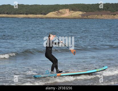 Gullane, East Lothian . Schottland Großbritannien 16th. März 21. Bei gutem Wetter trifft ein Stand Up Paddlebarder am Gullane Beach auf die Wellen. Kredit: eric mccowat/Alamy Live Nachrichten Stockfoto