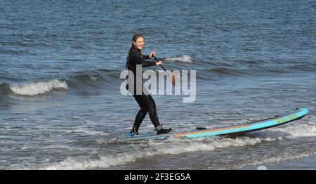 Gullane, East Lothian . Schottland Großbritannien 16th. März 21. Bei gutem Wetter trifft ein Stand Up Paddlebarder am Gullane Beach auf die Wellen. Kredit: eric mccowat/Alamy Live Nachrichten Stockfoto