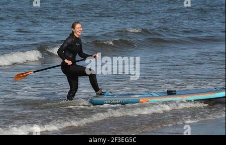 Gullane, East Lothian . Schottland Großbritannien 16th. März 21. Bei gutem Wetter trifft ein Stand Up Paddlebarder am Gullane Beach auf die Wellen. Kredit: eric mccowat/Alamy Live Nachrichten Stockfoto