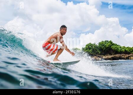 Dezember 30, 2020. Bali, Indonesien. Surfer-Fahrt auf Surfbrett bei Ocean Wave. Professionelles Surfen im Meer bei Wellen Stockfoto