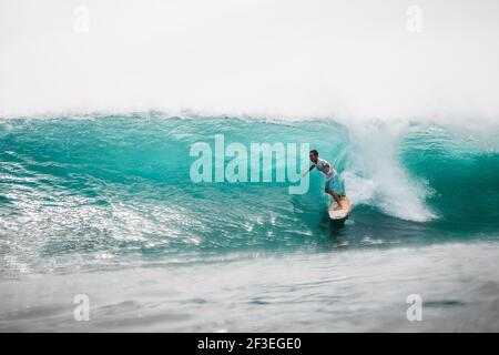 Dezember 30, 2020. Bali, Indonesien. Surfer-Fahrt auf Surfbrett bei Ocean Wave. Professionelles Surfen im Meer bei Wellen Stockfoto