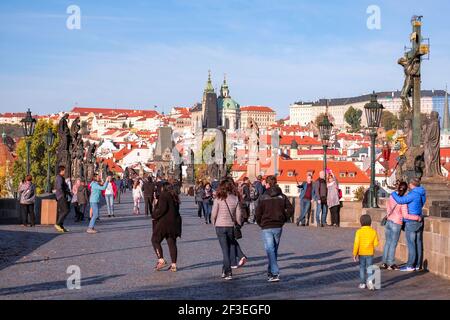 Touristen in Prag, Tschechische Republik. Karlsbrücke (Karluv Most) - schöner sonniger Tag mit dem Schloss und den Türmen im Hintergrund Stockfoto