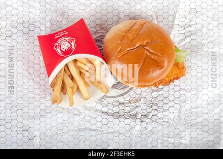 Wendy's Spicy Chicken Sandwich auf Wrapper mit Pommes aka Chips Stockfoto