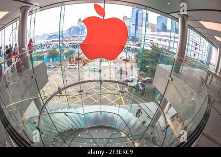 Hongkong, China - 4. Dezember 2016: Blick aus der Fischauge auf das Red Apple-Schild und eine moderne Wendeltreppe im Apple-Laden, IFC Mall, mit Beobachtung Stockfoto