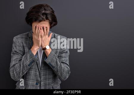 Traurige männliche Schrei, wobei in stressigen Situation isoliert auf schwarzem Hintergrund, das Tragen formeller Anzug, businessmat hac kein Erfolg bei der Arbeit Stockfoto