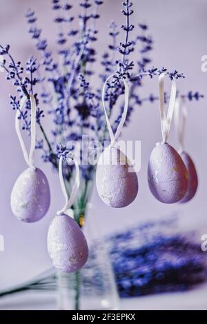 Lila Ostereier hängen an Lavendelzweigen Stockfoto