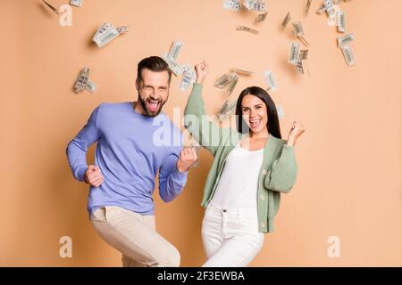 Foto von optimistisch schönes Paar gewinnen Geld tragen Pullover Hose Isoliert auf beigefarbenem Hintergrund Stockfoto