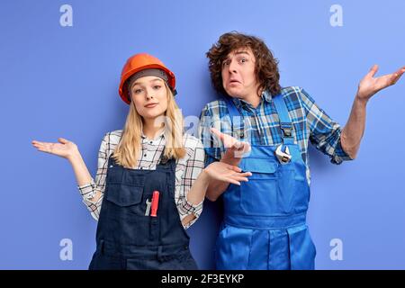 Team von Bauingenieuren tragen Uniform und Harthüte arbeiten in der industriellen Fabrik. Engineering- und Architekturkonzept. Mann und Frau misunderstandi Stockfoto
