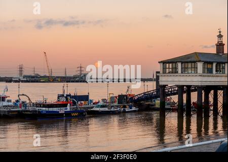 Vollmond steigt über dem neuen Tilbury 2 Terminal aus Die Themse am Gravesend mit dem Hafen von London Pier und Ponton im Vordergrund Stockfoto