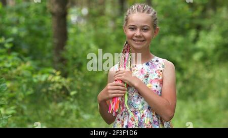 Teenager-Mädchen mit bunten Dreadlocks im Wald. Stockfoto