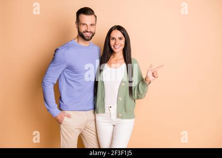 Foto von jungen glücklich lächelnd positive fröhliche Paar Frau Punkte Finger Copyspace isoliert auf beigefarbenem Hintergrund Stockfoto