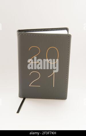 Eine vertikale Aufnahme eines Lederjournals mit '2021' Schrift Auf dem Cover auf weißem Hintergrund Stockfoto