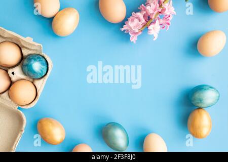 Ostereier, Blumen auf blauem Hintergrund. Flach liegend, Draufsicht, Kopierbereich. Ostertag. Stockfoto