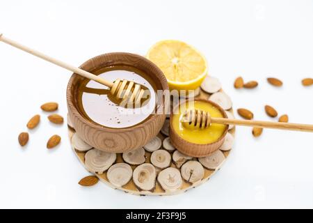 Honig in einer Holzschale und Orange auf einem weißen Hintergrund Stockfoto