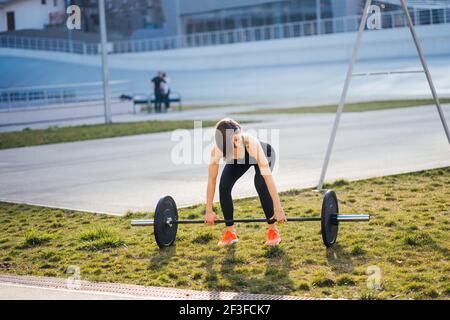 Starke Frau beim Training mit Langhantel. Nettes Mädchen Vorbereitung für Gewichtheben Training. Sport, Fitness-Konzept. Stockfoto