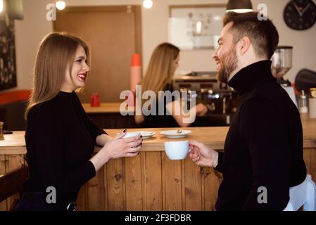 Schöne Frau Und Schöner Mann Trinken Kaffee Während Der Zeit Im Coffee Shop. Stockfoto