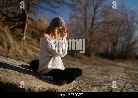 Praxis der Meditation und Interaktion mit der Natur. Mädchen in der Nähe des Flusses Stockfoto