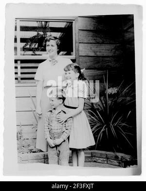 Mutter und Sohn und Tochter posieren vor dem Mittelklasse-Haus, 1950s, USA Stockfoto