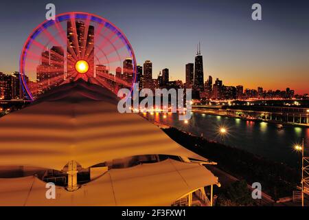 Chicago, Illinois, USA. Die Nacht überwindet die Dämmerung über dem Riesenrad am Navy Pier und der Skyline der Stadt. Stockfoto