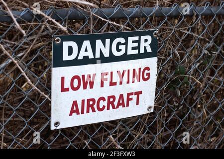 Blick auf das Schild Vorsicht Low Flying Aircraft am lokalen Flughafen in Courtenay, Kanada Stockfoto