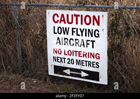 Blick auf Schild Vorsicht Low Flying Aircraft, No loitering Nächste 20 Meter am lokalen Flughafen in Courtenay, Kanada Stockfoto