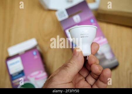 POV-Außenhandgriff mit neuer Philips Hue GU10-Farblampe Direkt nach dem Auspacken Stockfoto