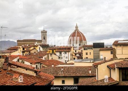 Dächer von Häusern und Gebäuden mit der Kuppel im Hintergrund in Florenz, Italien. Konzeptarchitektur. Stockfoto