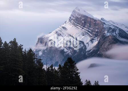Eine lange Exposition der Wolke und des Nebels, die sich um den Berg Rundle und den Tunnel Mountain in der unteren rechten Ecke bewegen. Stockfoto