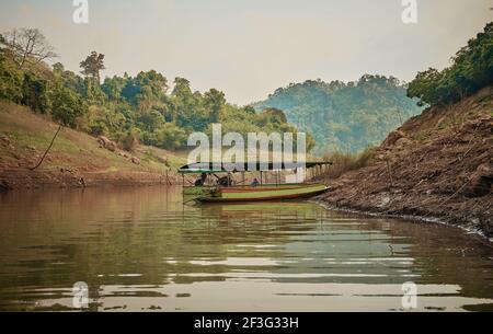 NAKORN NAYOK, THAILAND - MAR 13, 2021: Ein Touristenboot, das in Khun Dan Prakan Chon Dam in der Nakorn Nayok Provinz, Thailand segelt Stockfoto