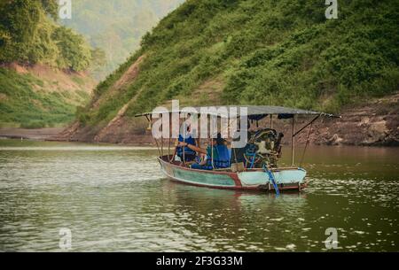 NAKORN NAYOK, THAILAND - MAR 13, 2021: Ein Touristenboot, das in Khun Dan Prakan Chon Dam in der Nakorn Nayok Provinz, Thailand segelt Stockfoto