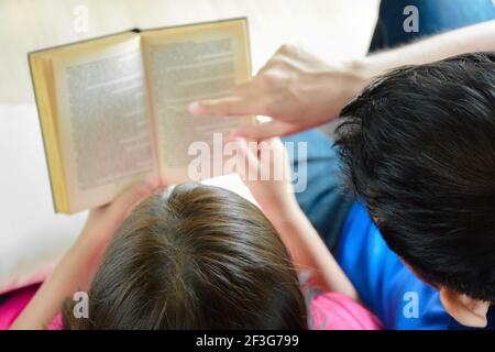 Pärchen sitzt zusammen, liest Buch - Draufsicht Stockfoto