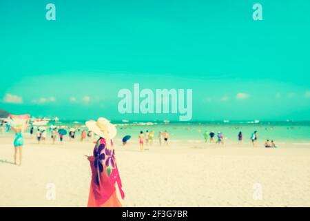 Verschwommene Menschen am weißen Sandstrand mit blauem Meer und Himmel Hintergrund - vintage Ton Stockfoto