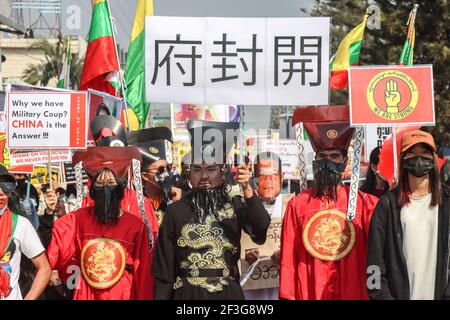Anti-Militär-Putsch-Demonstranten in berühmten alten chinesischen Richter (???) gekleidet Von Justice Bao mit einem Plakat in chinesischer Sprache, das "Offener Prozess" (???) bedeutet. Eine massive Menschenmenge ging auf die Straßen von Muse (burmesische Grenzstadt zu China), um gegen den Militärputsch zu protestieren und forderte die Freilassung von Aung San Suu Kyi. Das Militär von Myanmar nahm am 01. Februar 2021 die staatliche Beraterin von Myanmar Aung San Suu Kyi fest und erklärte den Ausnahmezustand, während sie die Macht im Land für ein Jahr nach Los ergattete Stockfoto