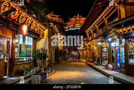 Shangrila , 8. Oktober 2020 : Dukezong Tibetische Altstadt szenische Straßenansicht mit Geschäften und Dafo Tempel beleuchtet in der Nacht im Hintergrund in Shangri-La Stockfoto