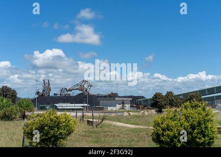 Mackay, Queensland, Australien - März 2021: Riesige Maschinen arbeiten an Kohlevorräten am Hay Point Kohleterminal Stockfoto