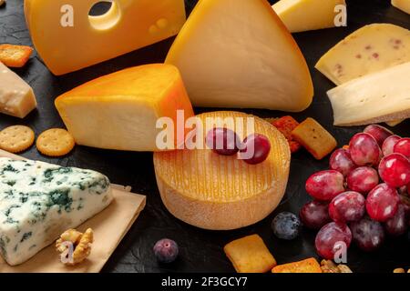 Käse und Trauben auf einem Tisch, eine Auswahl an verschiedenen Käsesorten Stockfoto